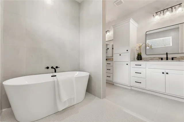 a spacious bathroom with a bathtub sink and mirror