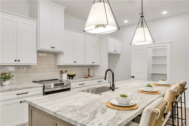 a kitchen with stainless steel appliances a table and chairs in it