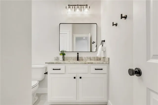 a bathroom with a granite countertop sink toilet a large mirror a bathtub and shower