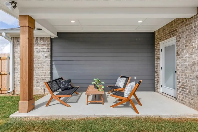 a view of a hallway with wooden floor and a bathroom