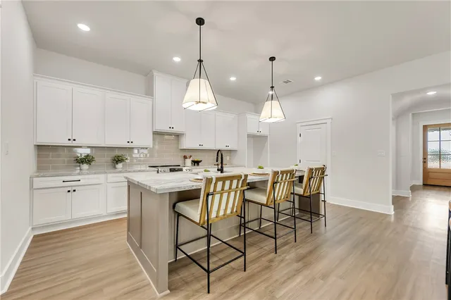 a kitchen with a table chairs sink and cabinets