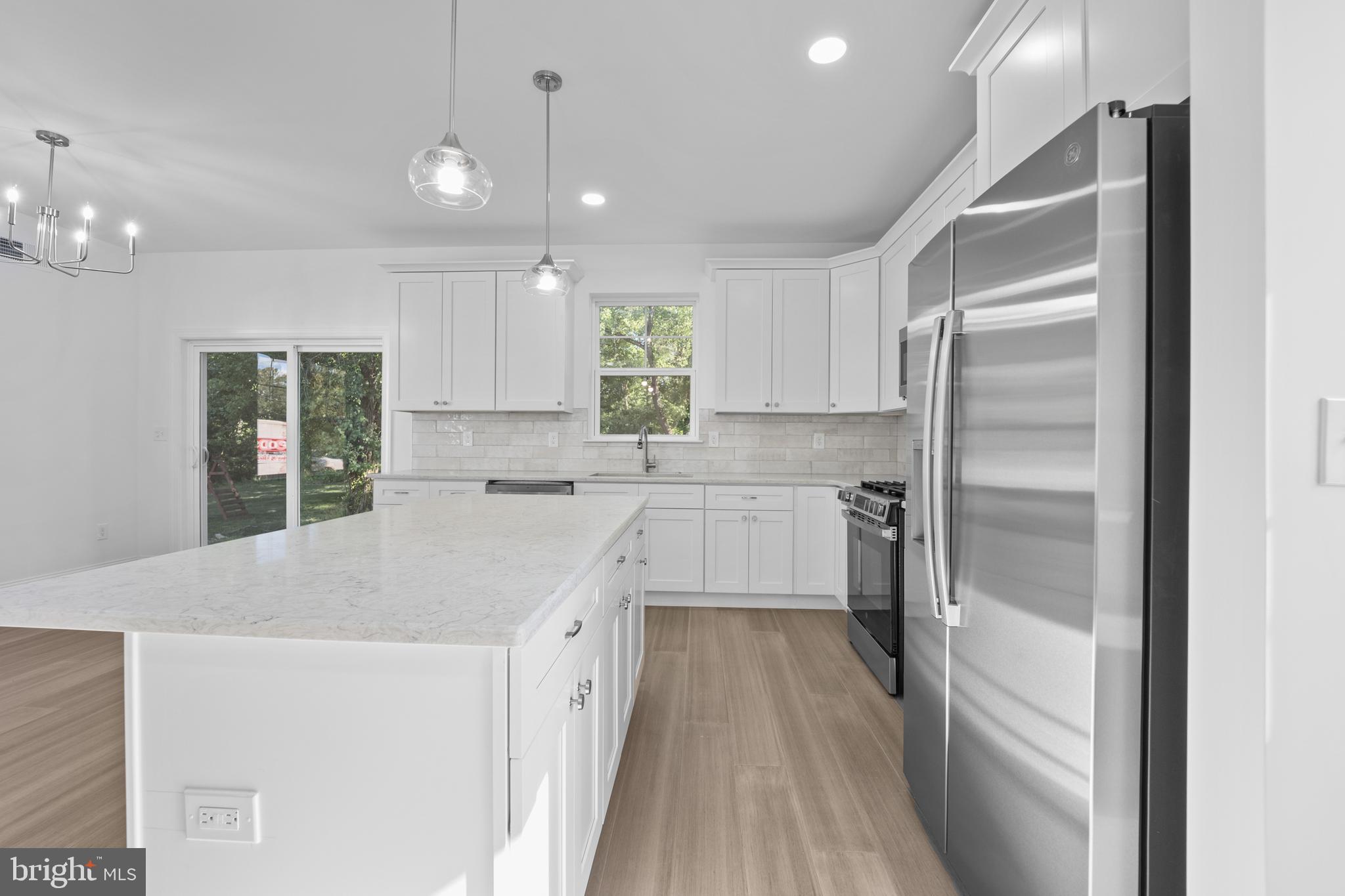 492 Ellis Avenue Lawnside, NJ 08045 - Photo 9 of 33 a kitchen with a refrigerator a sink and dishwasher with wooden floor