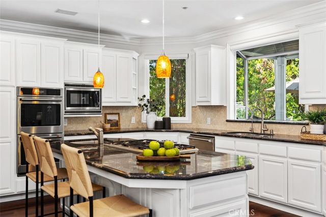 a kitchen with stainless steel appliances a sink a stove and a wooden cabinets