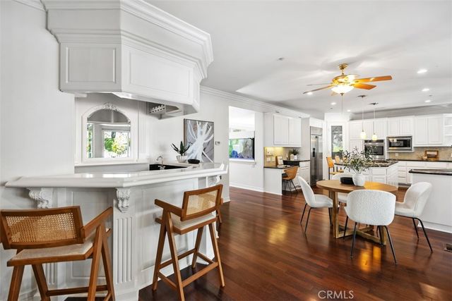 a kitchen with stainless steel appliances granite countertop a stove top oven a dining table and chairs with wooden floor