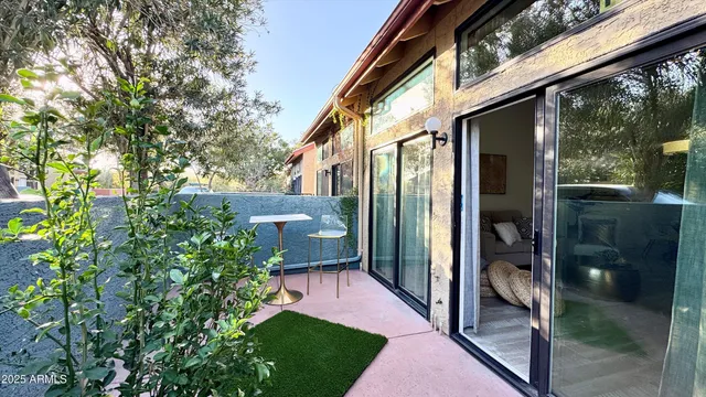 a view of a porch with plants and floor to ceiling window