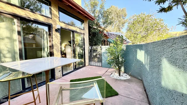 a view of a patio with table and chairs with wooden floor and fence