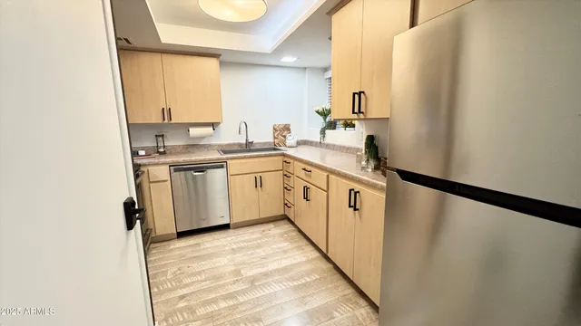 a kitchen with white cabinets sink and appliances