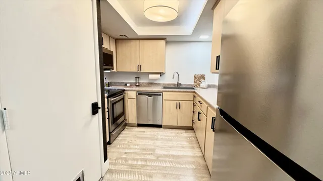 a kitchen with a sink a stove top oven and cabinetry