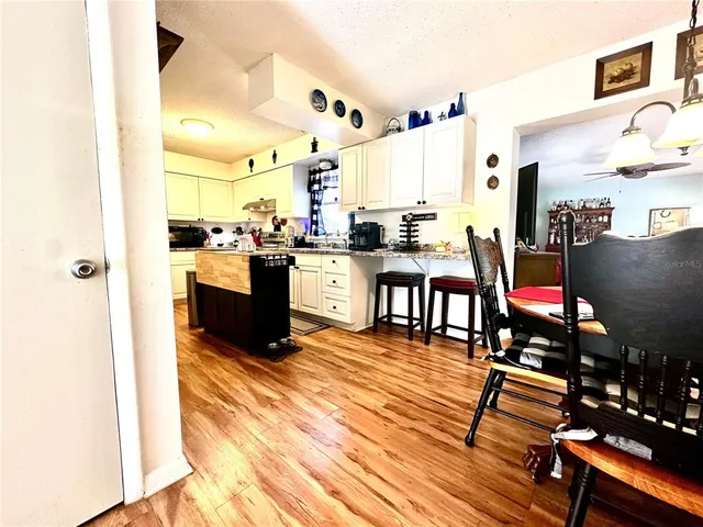 a living room with furniture a flat screen tv and kitchen view