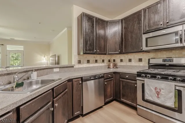 a kitchen with granite countertop cabinets stainless steel appliances and sink