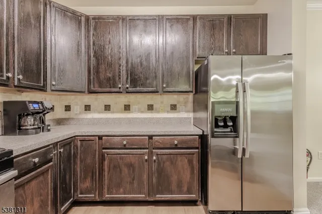 a kitchen with a sink a refrigerator and cabinets