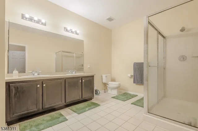 a spacious bathroom with a double vanity sink mirror and toilet