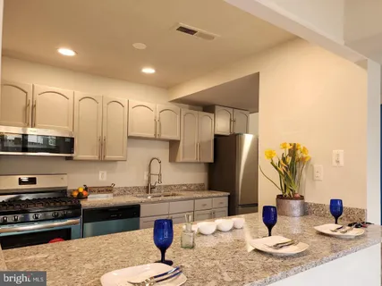 a kitchen with stainless steel appliances granite countertop a granite counter tops and a refrigerator