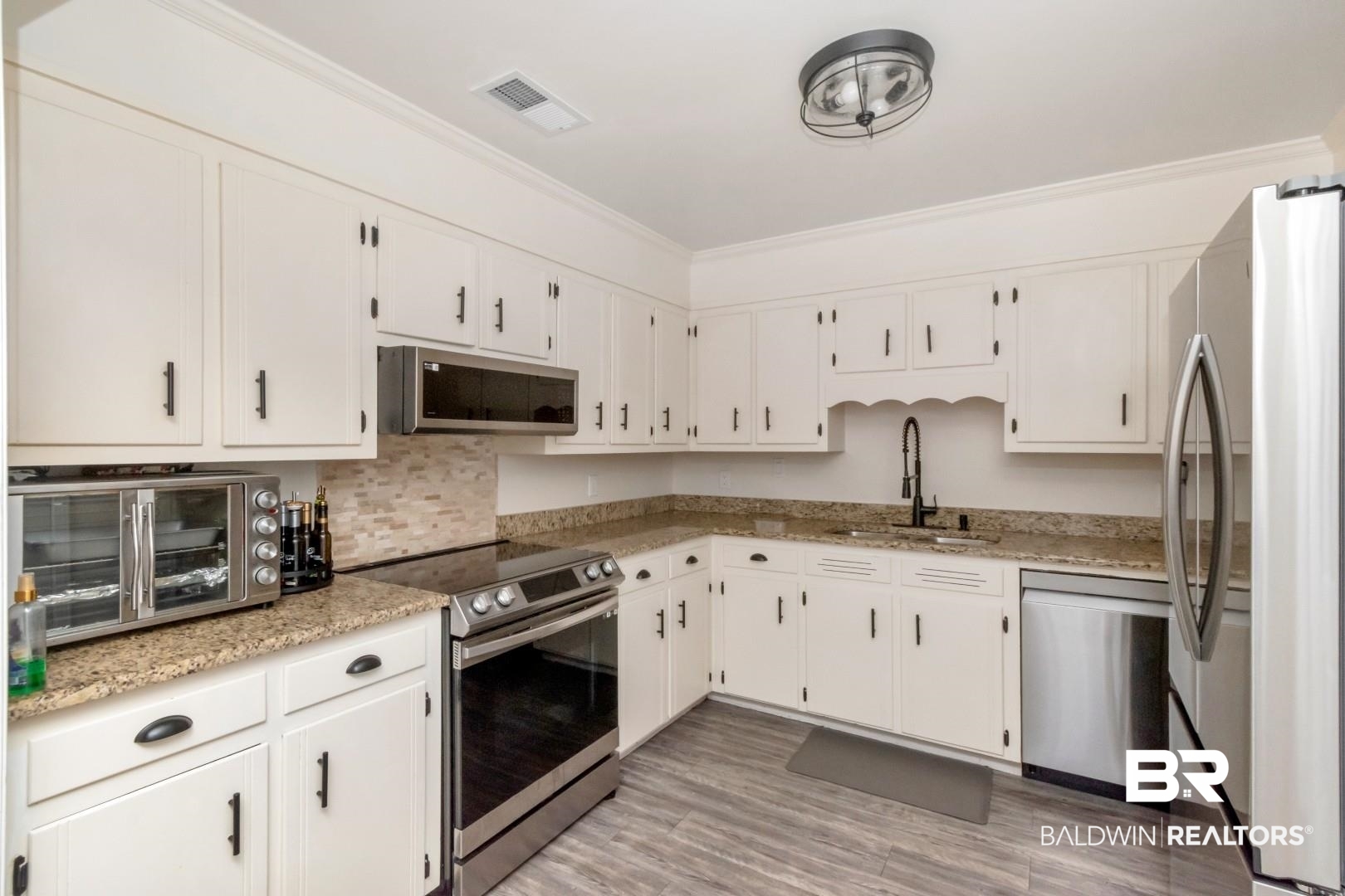 9410 Ashwood Court Mobile, AL 36695 - Photo 9 of 20 Kitchen featuring appliances with stainless steel finishes, light stone countertops, white cabinets, backsplash, and ornamental molding