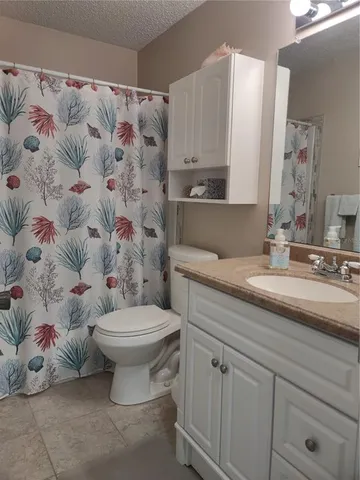 a bathroom with a shower a sink and toilet