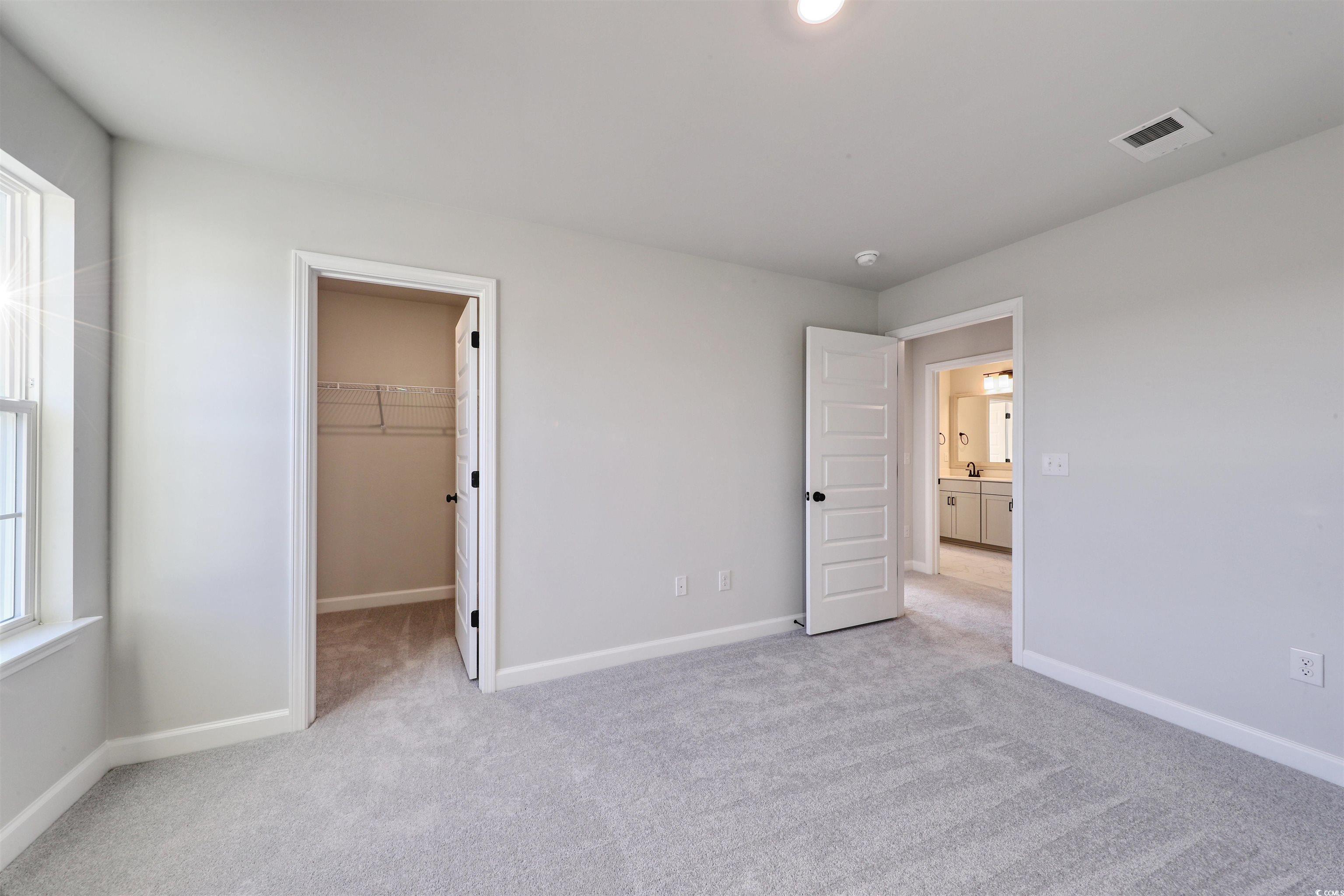 181 Azure Loop Myrtle Beach, SC 29588 - Photo 22 of 40 Unfurnished bedroom featuring a walk in closet, a