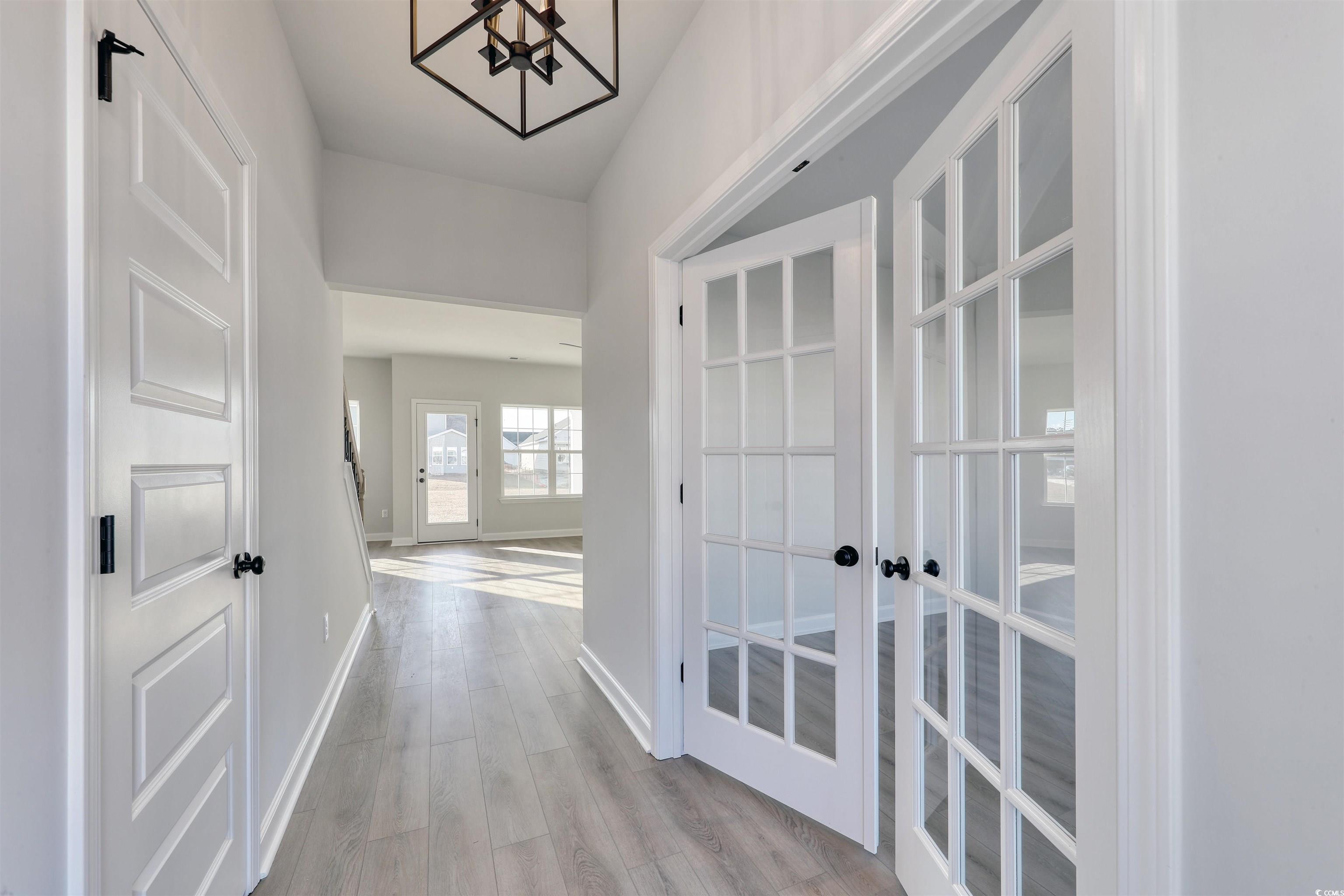 181 Azure Loop Myrtle Beach, SC 29588 - Photo 6 of 40 Hallway with french doors and light wood-type floo