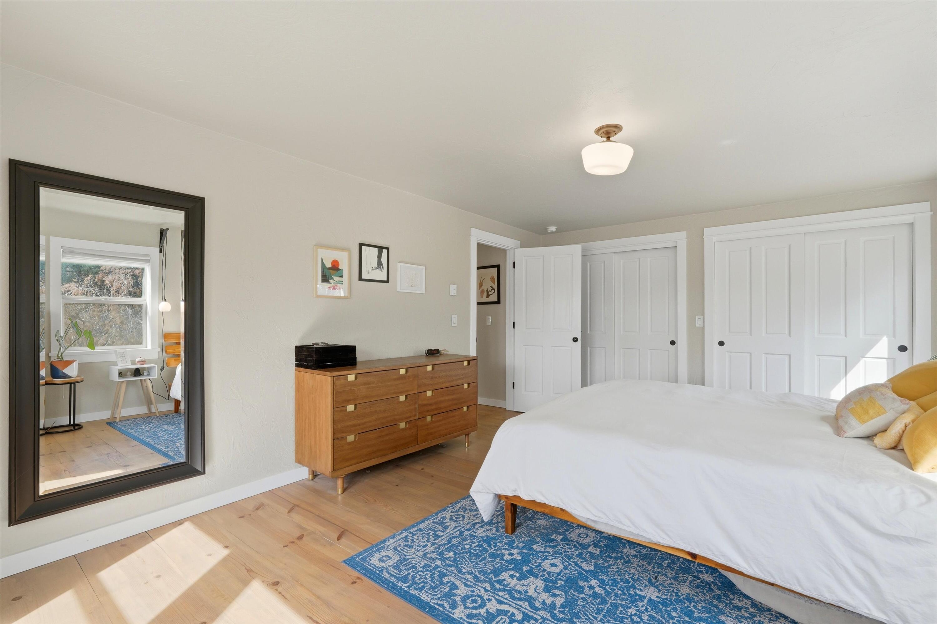 61280 Larsen Road Bend, OR 97702 - Photo 21 of 58 a spacious bedroom with a bed and a dresser