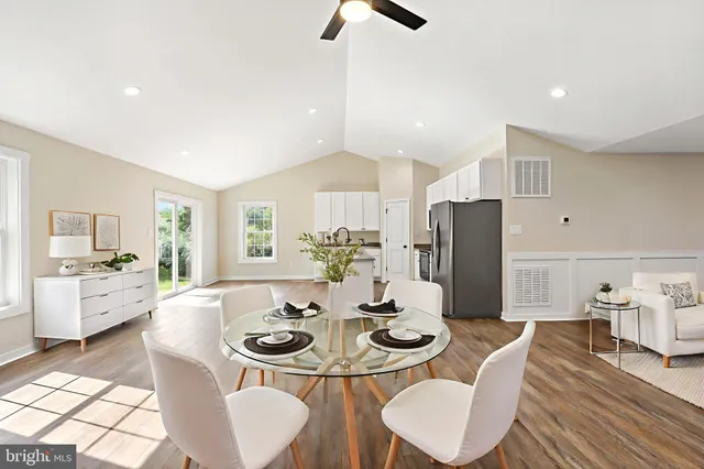 a view of a dining room with furniture a rug and wooden floor