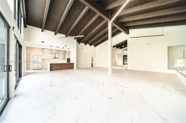 a large white kitchen with a sink and stainless steel appliances