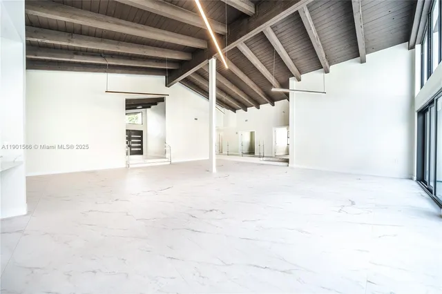 a view of a kitchen with refrigerator and white cabinets