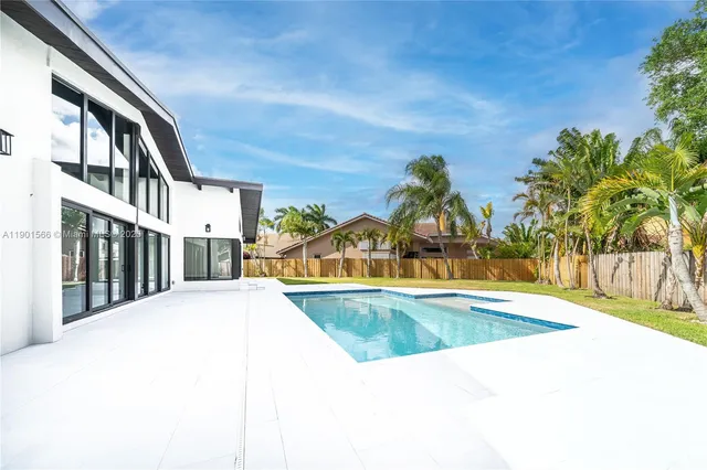a front view of house with yard and palm tree