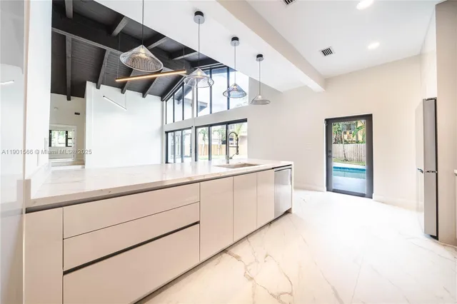 a view of a hallway with wooden floor and a living room