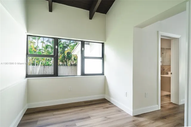 a large white kitchen with a sink and a large mirror