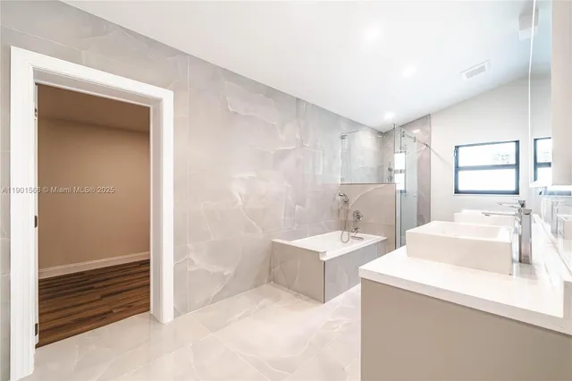 a view of an empty room with wooden floor and a floor to ceiling window