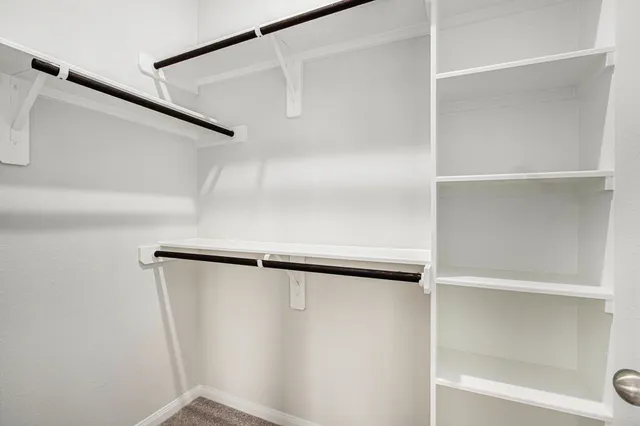 a view of walk in closet with empty racks