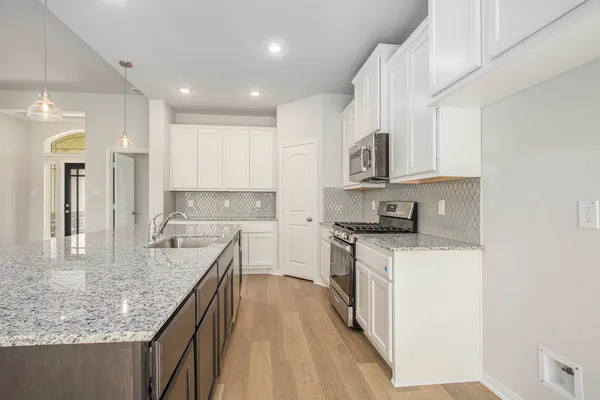 a kitchen with stainless steel appliances granite countertop a sink stove and refrigerator