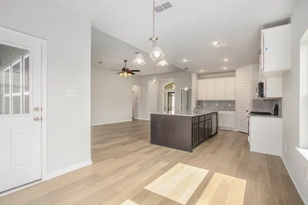 a large kitchen with a refrigerator a stove top oven and a sink