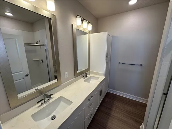 a bathroom with a double vanity sink and mirror