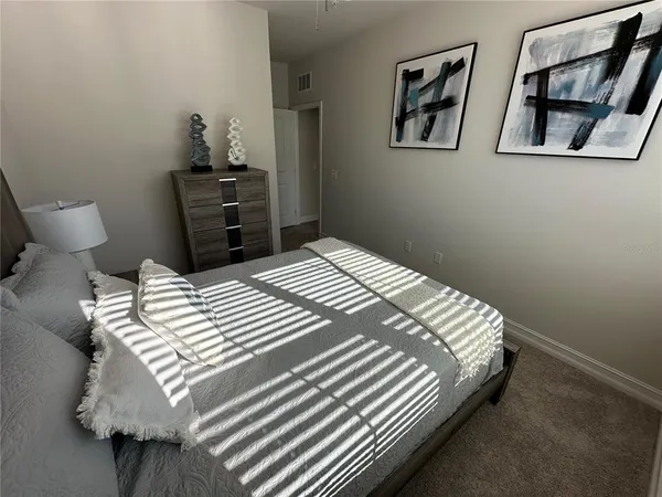 a bedroom with a bed and painting on the wall