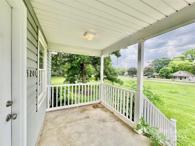 a view of a porch with wooden floor in front of a house
