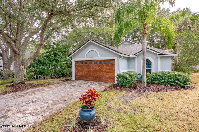 a front view of a house with a yard and potted plants