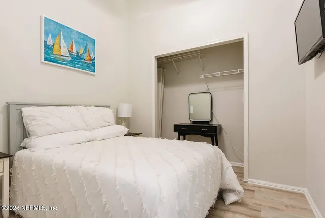 a bedroom with a bed and a painting on the wall