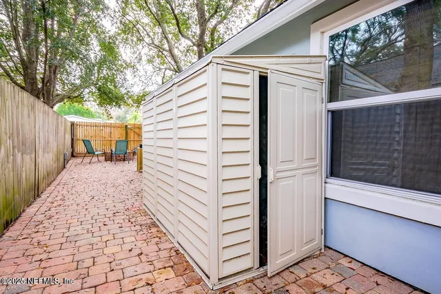 a view of a house with a door and wooden bench