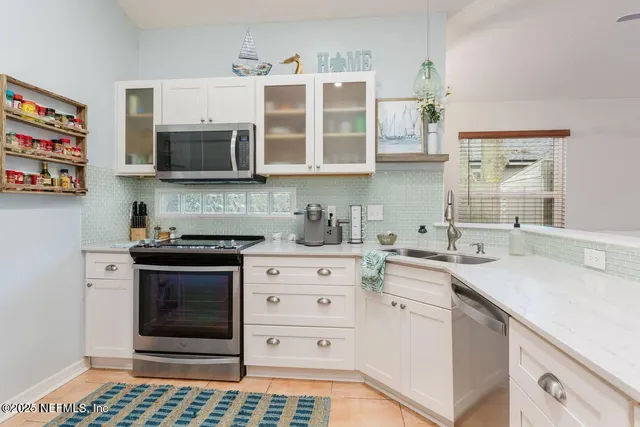 a kitchen with stainless steel appliances granite countertop a sink a stove and a microwave