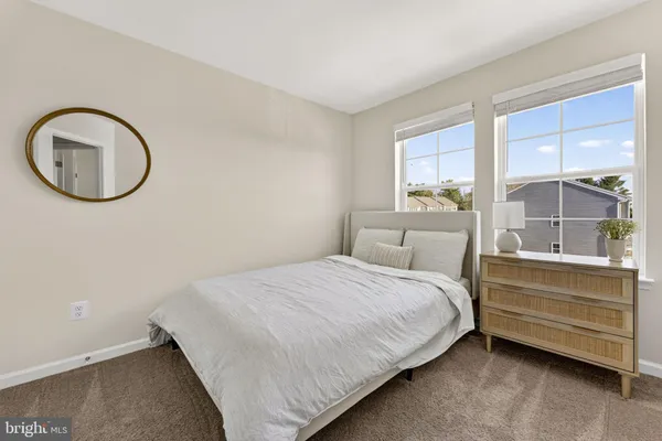 a bedroom with a bed a mirror and a large window