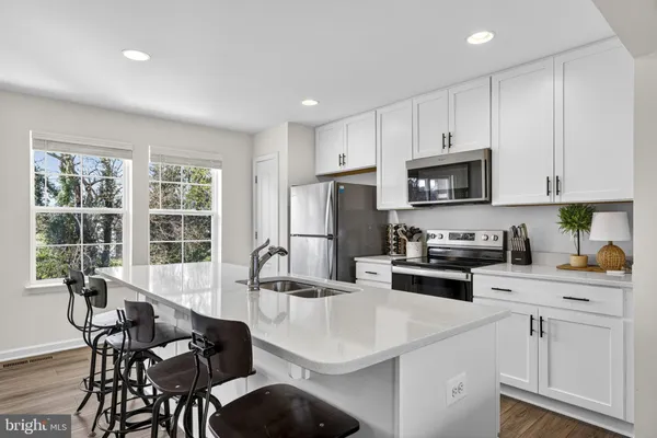 a kitchen with appliances a sink and cabinets