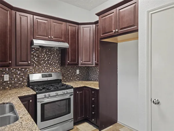 a kitchen with granite countertop cabinets and steel stainless steel appliances
