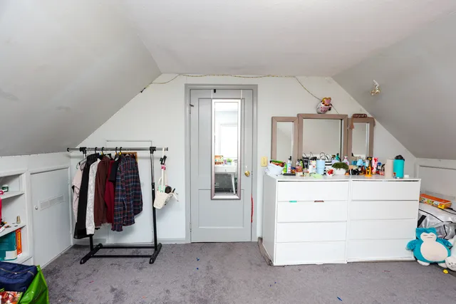 a bedroom with a bed and a flat tv screen on a dresser