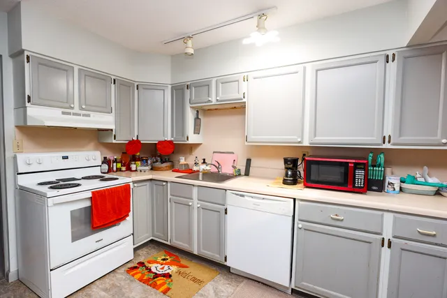 a kitchen with stainless steel appliances granite countertop a refrigerator and a stove