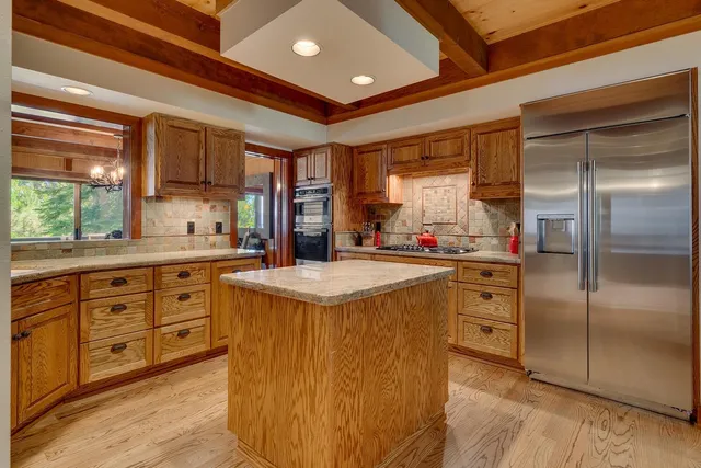 a kitchen with stainless steel appliances granite countertop a sink a stove and a refrigerator