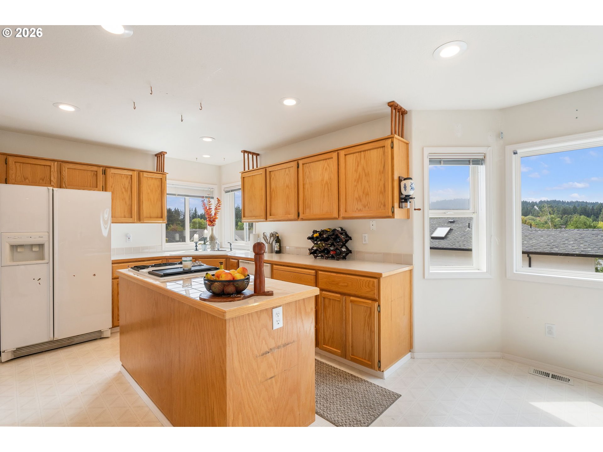 8943 Southwest 149th Place Beaverton, OR 97007 - Photo 11 of 41 a kitchen with stainless steel appliances granite countertop a refrigerator a sink a stove and white cabinets with wooden floor