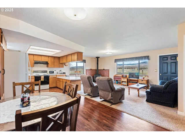 a living room with furniture kitchen view and a large window