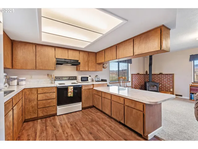 a kitchen with stainless steel appliances granite countertop a stove refrigerator sink and cabinets