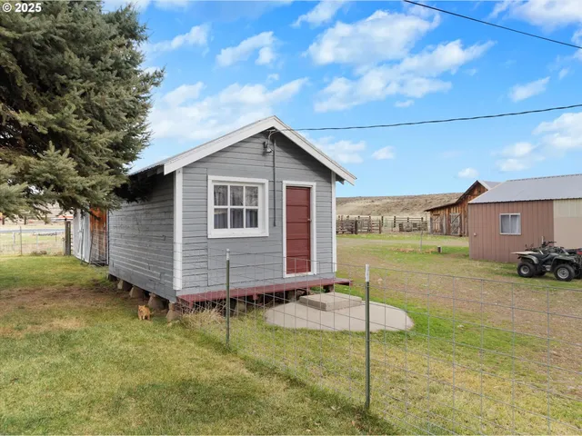 a view of a house with a yard and fence