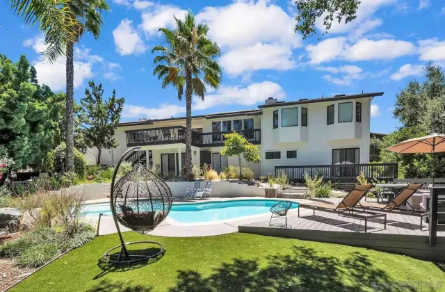a front view of a house with swimming pool table and chairs